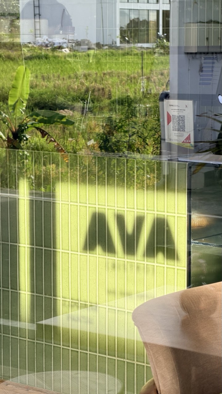 AVA signage seen through green tiled glass
